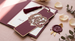 Laser die cut bookmark in an intricate heart and monogram design, deep burgundy stock with a gold tassel, styled with a wax seal, dried petals, and eucalyptus for a wedding stationery suite — custom laser die cut bookmark example