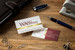 Wang & Associates gold foil business cards in burgundy and white, styled on a wood desk with a fountain pen — law firm business card design"