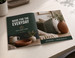 Saddle stitch catalog on a desk, stapled along the folded spine and lying open — the economical binding for lower page-count catalogs, programs, and product booklets.