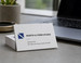 Silk business cards with a fast turnaround, fanned out on a desk next to a laptop - the smooth, soft-touch silk laminate finish is visible up close, ready for quick-turn orders. - printshaQ