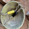 Glossy yellow and glossy black cremation ash beads on a sterling silver bracelet chain.