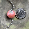 Shown in Pink, cremation ash bead by Sisu Beads. This is a glossy glaze.