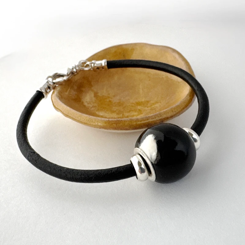 Black and white ash bead on black leather.