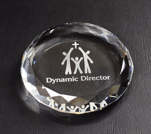 round crystal paperweight engraved with text and logo