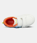 White kids sneaker with dual self‑fastening straps and contoured footbed