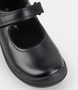 Black leather girls Mary Jane school shoe with smooth upper and hook‑and‑loop strap.