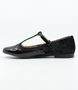 Black girls patent and suede T‑bar shoe with buckle strap and brogue detail.