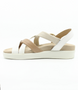 White Combo women’s synthetic crossover strap sandal with cushioned footbed and gold buckle ankle strap.