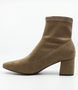 Taupe women’s stretch suede ankle boot with pointed toe and block heel.