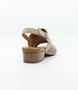 Beige women’s laser‑cut leather sandal with adjustable strap and low block heel.