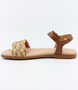 Tan girls’ woven leather flat sandal with ankle strap and cushioned footbed.