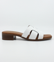 White women’s criss‑cross leather low‑heel slide sandal with cushioned footbed.