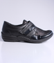 Black women's leather and fabric comfort shoe with textured panels, hook-and-loop strap and cushioned footbed.