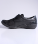 Black women's leather and fabric comfort shoe with textured panels, hook-and-loop strap and cushioned footbed.