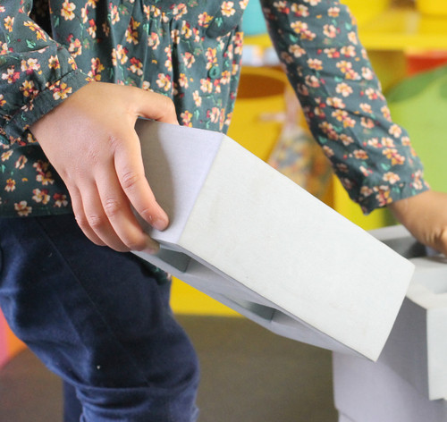 Child holding grey brick
