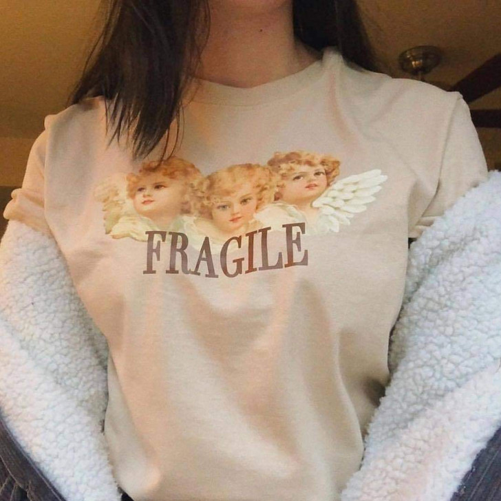 fragile tee in khaki with the picture of three baby angels