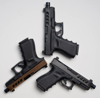 Three Glock 19s with True Precision Axiom slides and black nitride threaded barrels in a triangle pattern