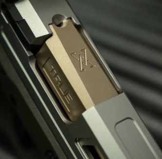 A close up shot of a Springfield Hellcat Pro with non-threaded FDE True Precision barrel
