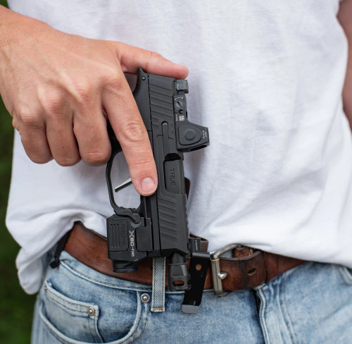 A Sig P365 with a True Precision threaded duty barrel in black nitride, being put into a holster