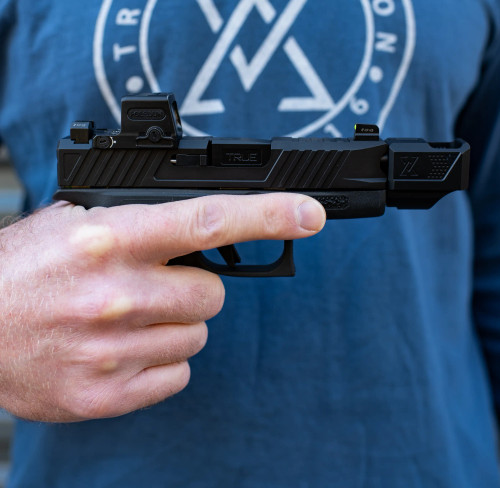 True Precision Glock 43 with black duty slide and black threaded barrel with black compensator.