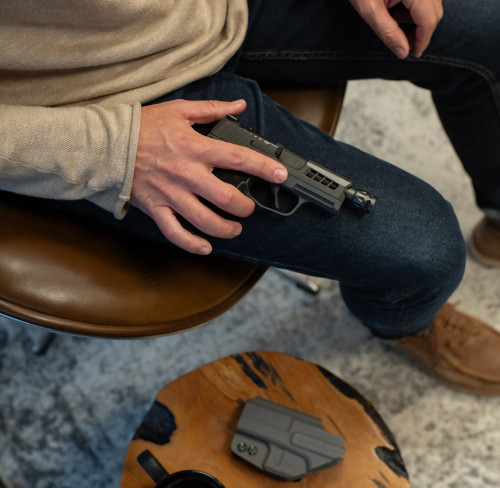 Sig P365 being held on some ones leg, with True Precision threaded barrel and Axiom slide.