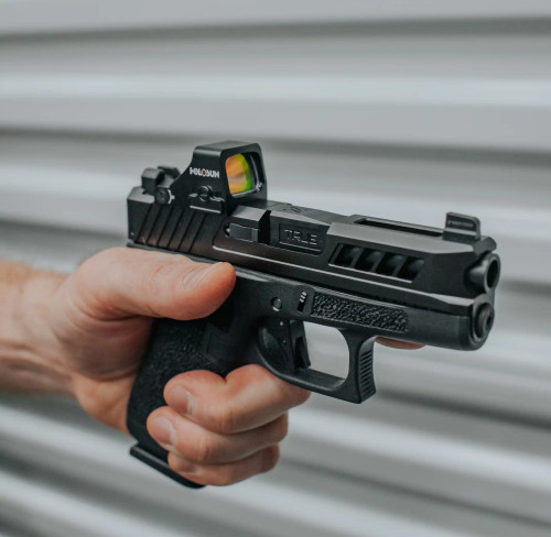 Glock 43X with Black DLC non-threaded barrel being held over a grey corrugated background.