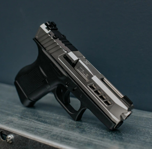 Glock 43 with Satin Stainless non-threaded barrel, and Axiom slide, on a metal bar with blue background.