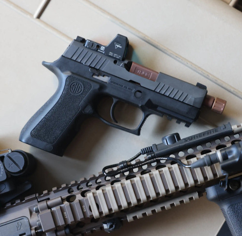 Sig P320 Compact with a True Precision threaded barrel in copper TiCN laying next to an AR-15