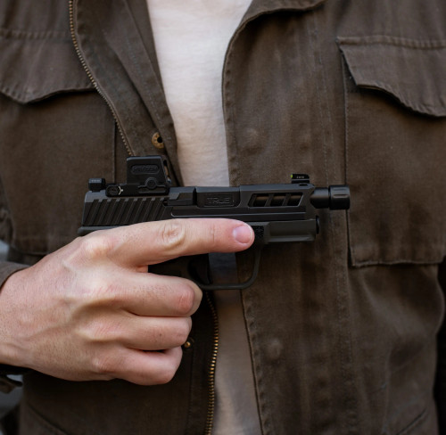 True Precision Springfield Hellcat with black threaded barrel and slide, being held.