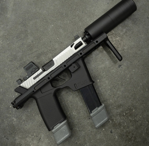 True Precision P365 Flux Extended 6.5" barrel with a black suppressor, on concrete background