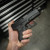 True Precision Glock 26 with Stealth Grey Threaded barrel, being held above a tool box True Precision Glock 26 with Stealth Grey Threaded barrel, being held above a tool box