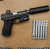 a Glock 19 with a True precision threaded barrel in Stainless, with a black suppressor, and stainless barrels lined up next to it