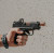 A Springfield Hellcat with True Precision threaded barrel and Y-Type Micro compensator in copper TiCN being held against a beige textured background