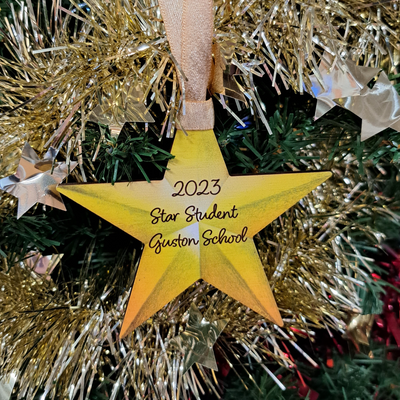 Wooden Gold Star Decoration hanging on the Christmas Tree with the words '2023 Star Student'