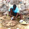 Haitian Metal Artisans in Croix-des-Bouquets cleaning, burning, flattening used oil barrels to use for metal art. Haitian metal artist sketching design in