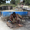 Haitian Metal Artisans in Croix-des-Bouquets cleaning, burning, flattening used oil barrels to use for metal art. Haitian metal artist sketching design and then using a hammer and chisel to pound design into metal.