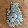 Recycled steel drum art, hand-hammered by Haitian artisans into an owl and skull wall hanging