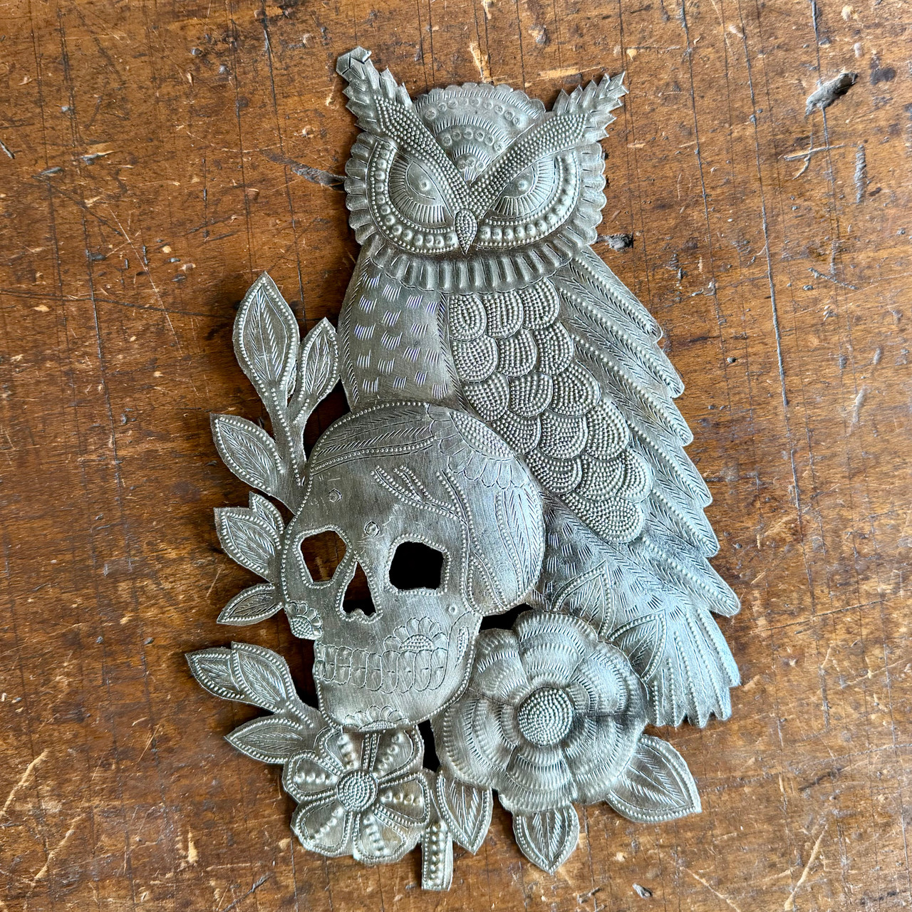 Recycled steel drum art, hand-hammered by Haitian artisans into an owl and skull wall hanging