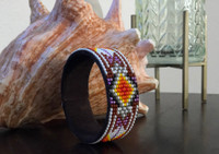 Luminous seed beads stitched onto suede leather over adjustable cuff – one size fits most. 1” x 5.75”
