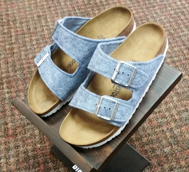 Light blue felt Birkenstock sandals with two adjustable buckle straps and cork footbeds.