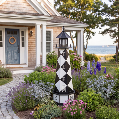 Coastal cottage with Cape Lookout replica PVC lighthouse in flower bed.