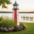 Amish crafted poly patriotic garden lighthouse in backyard flower bed