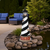 Amish made Cape Hatteras replica garden lighthouse finished in black and white with cherrywood and weatherwood base, pictured by patio water garden.