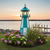 Amish crafted Cape Henry style premium poly garden lighthouse pictured in aruba blue and white by a dock at sunset
