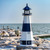 Montauk, NY replica garden lighthouse, Amish crafted poly in patriot blue and white, pictured on a rocky beach