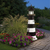 Amish crafted Bodie Island replica poly garden lighthouse, pictured along a garden path