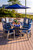 Surf-Aira Amish crafted poly dining table & Ocean Wavz chairs in patriot blue and light gray, pictured on deck at the beach