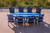 Surf-Aira Amish crafted poly dining table & Ocean Wavz chairs in patriot blue and light gray, pictured on deck at the shore