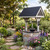 Amish handcrafted poly and gray stone wishing well, pictured along a flower garden path