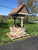 Amish handcrafted stone and poly wishing well, size jumbo, birchwood frame with mahogany, brown stone with tan grout.